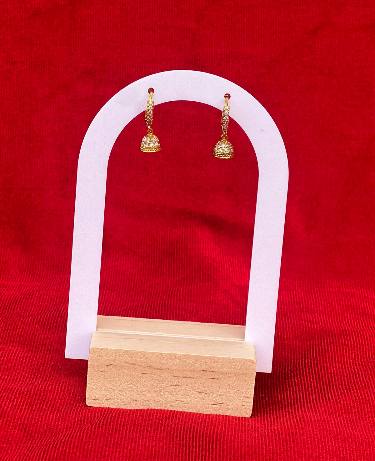 Jharna gold plated jhumka drop earrings on arch display stand