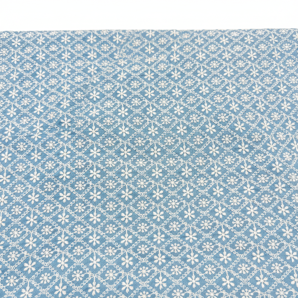 Close-up Chikankari embroidery detail on sky blue fabric